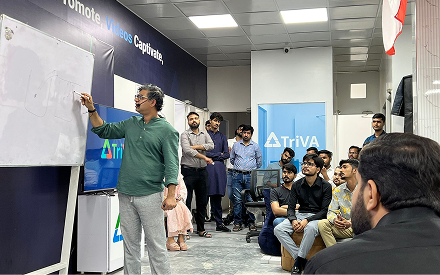 Ash Ali working through ideas at a whiteboard with a small group of founders