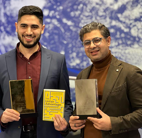 Ash Ali and Hasan Kubba holding awards and The Unfair Advantage book